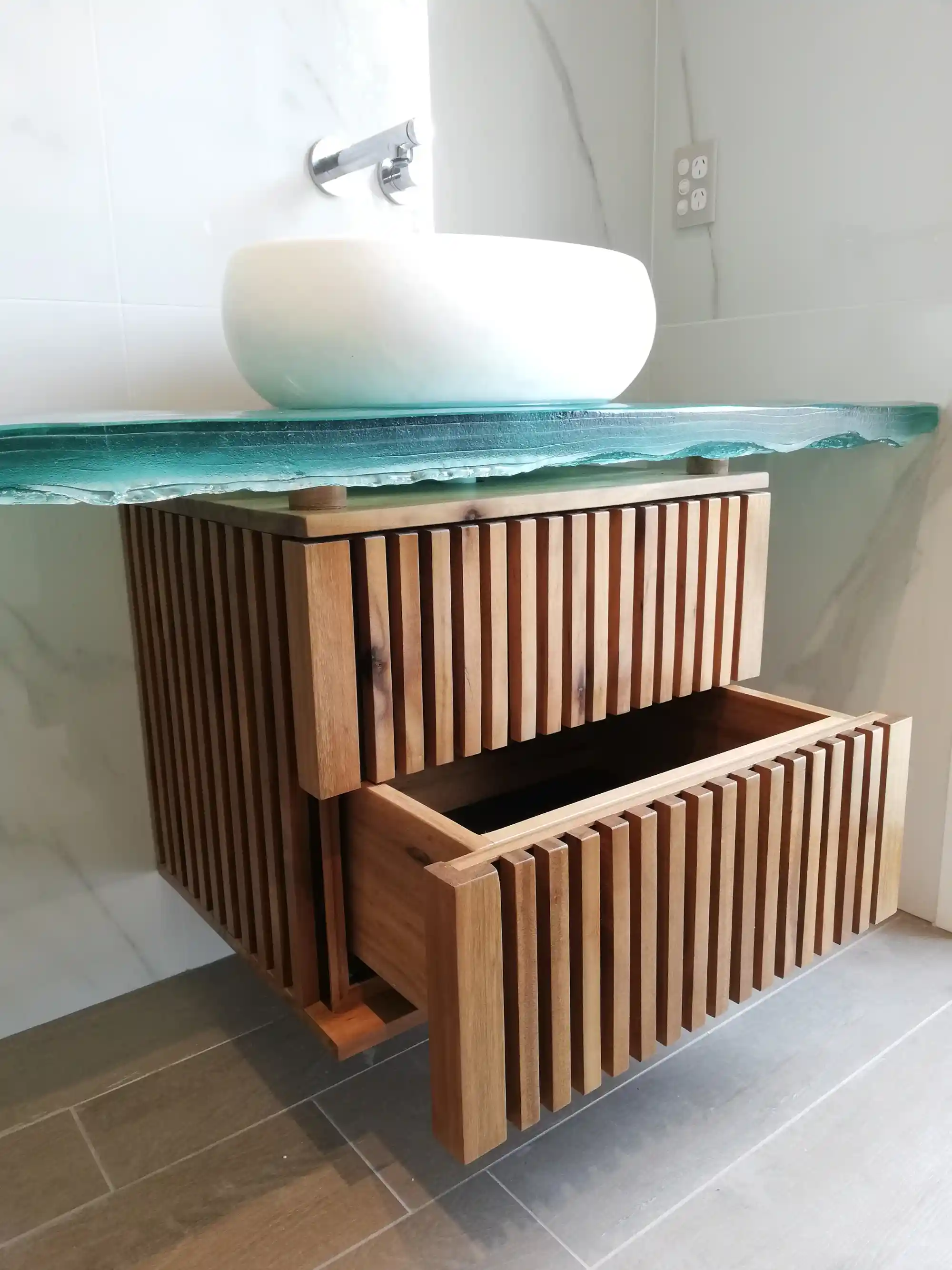 Greenheart timber base supporting a sculptural glass vanity top