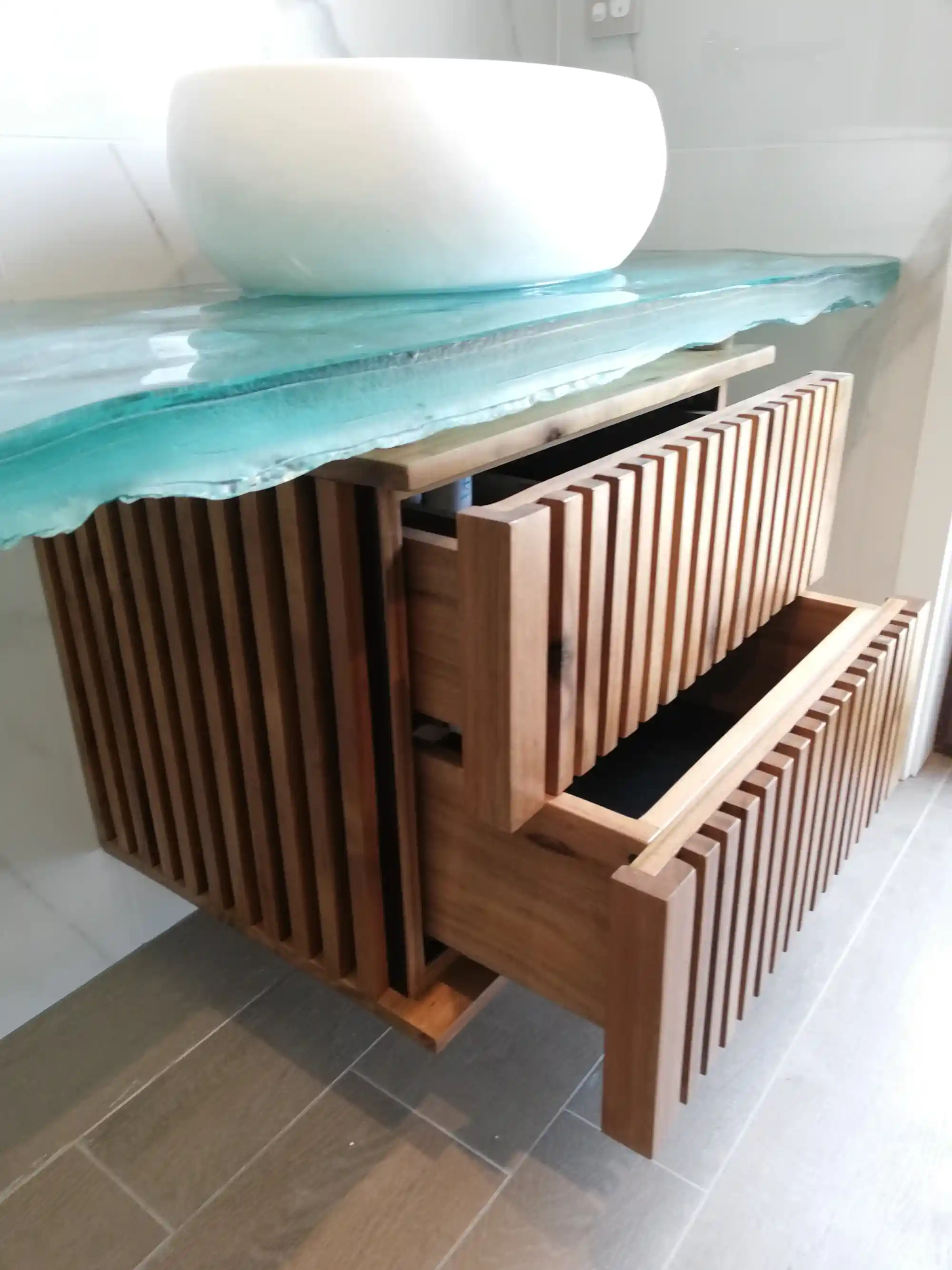 Vertical timber details guiding attention towards the glass vanity top